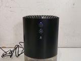 an air purifier sitting on top of a table next to a wall