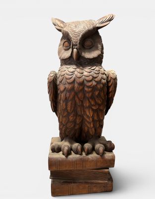 an owl statue sitting on top of a wooden block