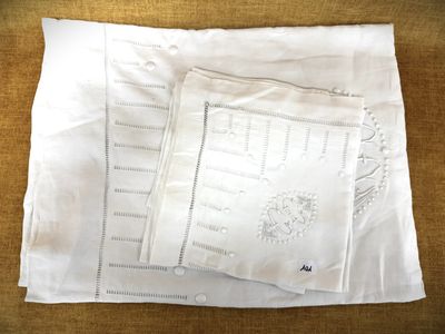 deux taies d'oreiller blanches ornées de motifs brodés, posées sur une table