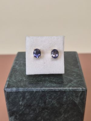 a pair of blue sapphire earrings sitting on top of a marble block