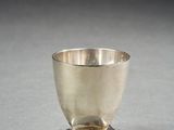a silver cup sitting on top of a saucer