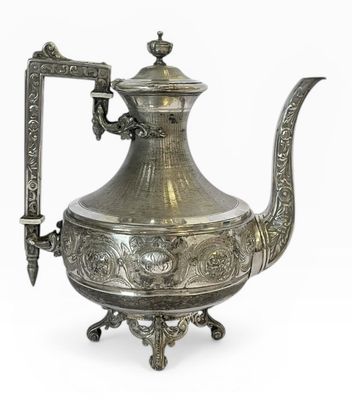 une théière ancienne en argent avec une anse et une poignée, sur fond blanc