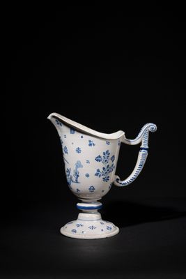 a blue and white vase with a handle on a black background