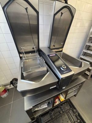 two stainless steel ovens in a kitchen with tiled walls