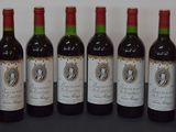 six bouteilles de vin sont alignées sur une table