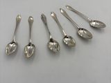 six silver spoons are arranged in a row on a white surface