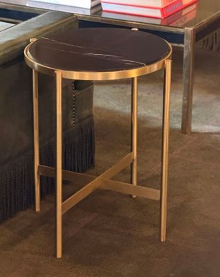 a black and gold side table with books on top of it