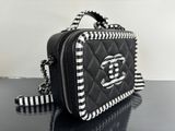 black and white quilted purse with chain strap on black table