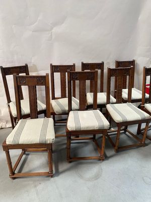 six chaises et une table sur laquelle est posé un coussin rayé