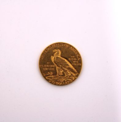 a gold coin with a bird on it on a white surface