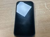 un téléphone portable posé sur une table, avec un bout de papier dessus