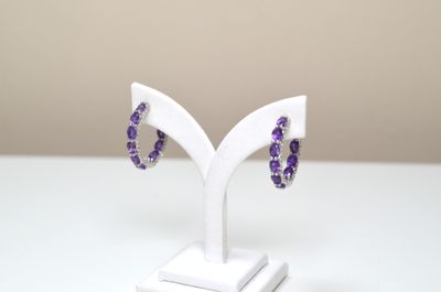 Une paire de boucles d'oreilles style créoles en argent sert…