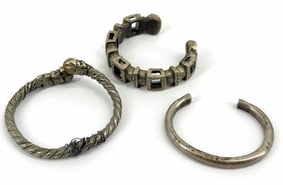 three pieces of silver jewelry on a white surface with a white background