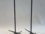 a pair of black metal candles on stands with a white background