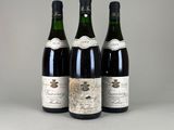 trois bouteilles de vin posées sur une table l'une à côté de l'autre