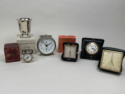 de nombreuses horloges de toutes sortes, posées sur une surface blanche