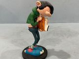 the figurine of a man with a book is standing on a table