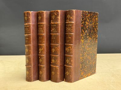 trois vieux livres posés l'un sur l'autre sur une table