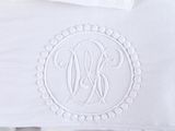 a white table cloth with a monogram on it