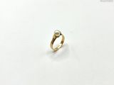 a close up of a gold ring with a pearl on it