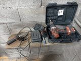 une boîte à outils contenant un marteau, une perceuse et d'autres outils, posée sur une table