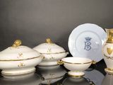 un ensemble de plats blancs et dorés posés sur une table noire
