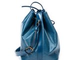 the small blue bucket bag is on a white surface