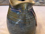 un vase bleu et vert posé sur une table