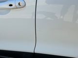 un gros plan sur la poignée de porte d'une voiture blanche