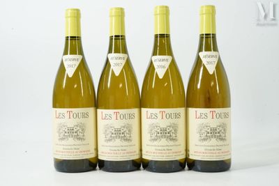 quatre bouteilles de vin sont alignées sur une surface blanche