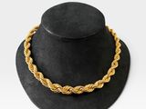 un chapeau noir surmonté d'un collier en corde dorée