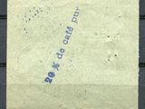 un vieux timbre sur lequel figure une inscription bleue, posé sur un morceau de papier