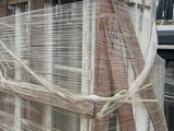 a truck that is parked next to a building that has been wrapped in plastic