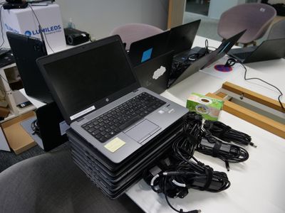 un ordinateur portable posé sur une pile de câbles d'alimentation