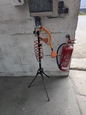 un extincteur posé sur un trépied à côté d'une borne d'incendie