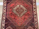 a red and black rug with a medallion design on it