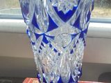 a blue glass vase sitting on top of a table