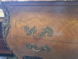 a wooden dresser with a marble top and brass handles