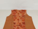 an orange and brown vest with a floral design on it