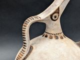 a white vase with a brown handle on a black background