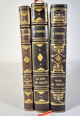 three old books sitting on top of each other on a white surface