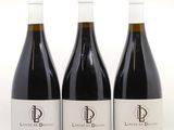 trois bouteilles de vin rouge posées sur une table blanche