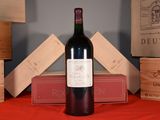 a bottle of wine sitting on a table next to a stack of wooden boxes