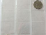 three coins in a clear plastic bag on a table