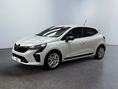 Une voiture blanche est garée dans une pièce au sol gris.
