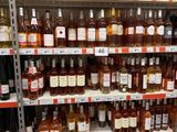 bottles of alcohol on a shelf in a store for sale