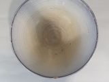 a glass with a liquid inside of it on a table