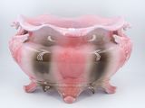 a pink vase that is sitting on a stand