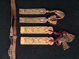 trois marque-pages en bois avec des pompons et un cordon en cuir