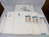 cinq serviettes pliées posées sur une table blanche